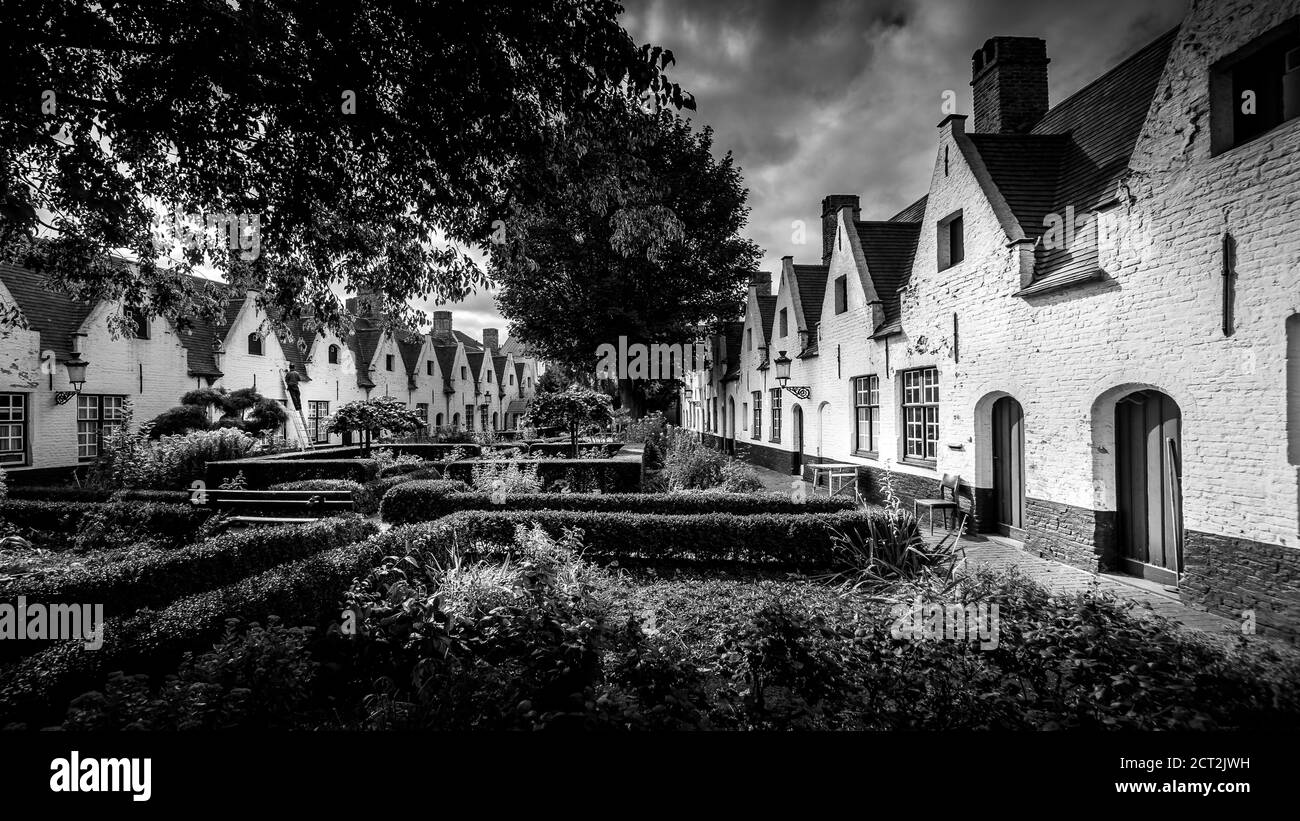 Photo en noir et blanc de la 'Béguinage princière de Wijngaarde' avec ses façades de maisons de couleur blanche et le paisible jardin du couvent fondé en 1245 Banque D'Images