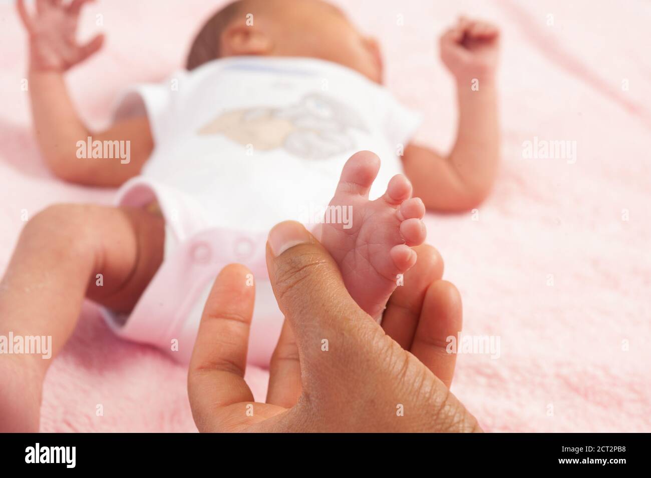Nouveau-né bébé fille de 12 jours gros plan du réflexe de pied La mère Babinski appuie sur le côté du pied et les orteils en éventail Banque D'Images