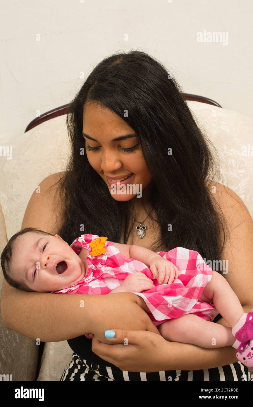 bébé fille de 3 semaines nouveau-né avec boursouflure de soins sur la lèvre, tenue par la sœur aînée adolescente, 14 ans, bâillement réflexe Banque D'Images
