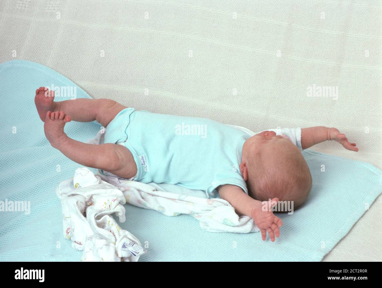 Nouveau-né bébé fille, 3 semaines, sur le dos, pleine longueur, réflexe: L'amidé (Moro reflex) Banque D'Images