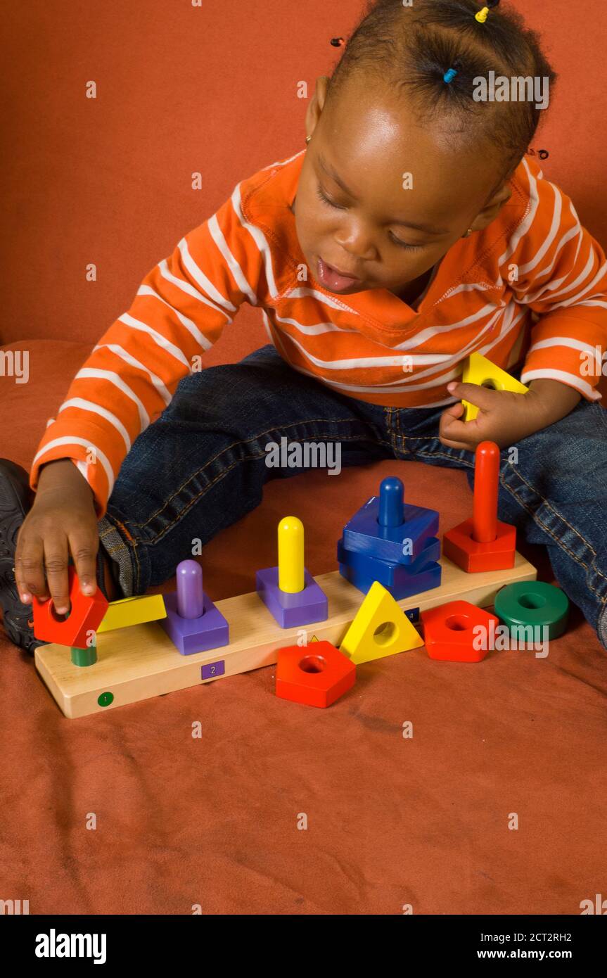 enfant de 20 mois bébé fille jouant avec un jouet coloré trieur vertical en  bois de forme géométrique Photo Stock - Alamy