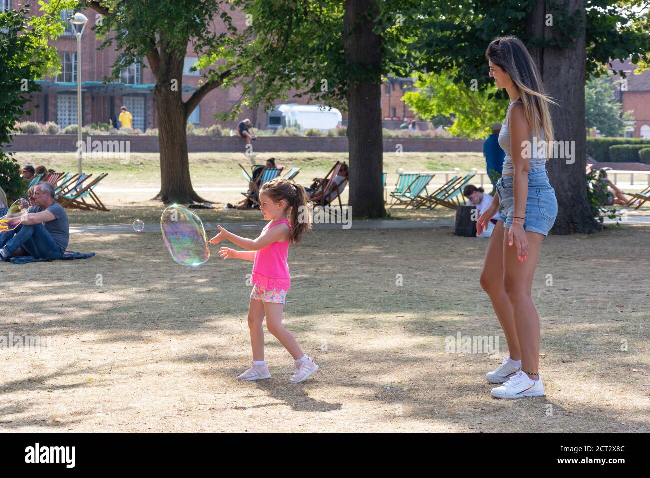 Enfant et mère jouant avec une bulle géante dans Bancroft Gardens, Stratford-upon-Avon, Warwickshire, Angleterre, Royaume-Uni Banque D'Images