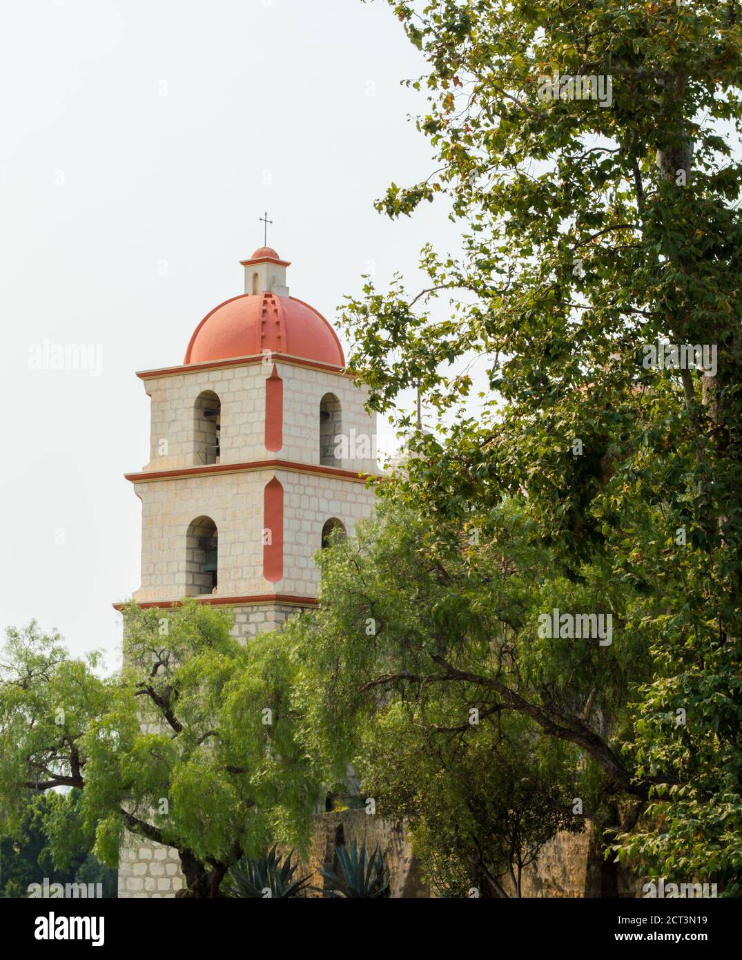 Clocher néoclassique de la mission historique de Santa Barbara au milieu arbres luxuriants sous un soleil brumeux avec espace de copie Banque D'Images