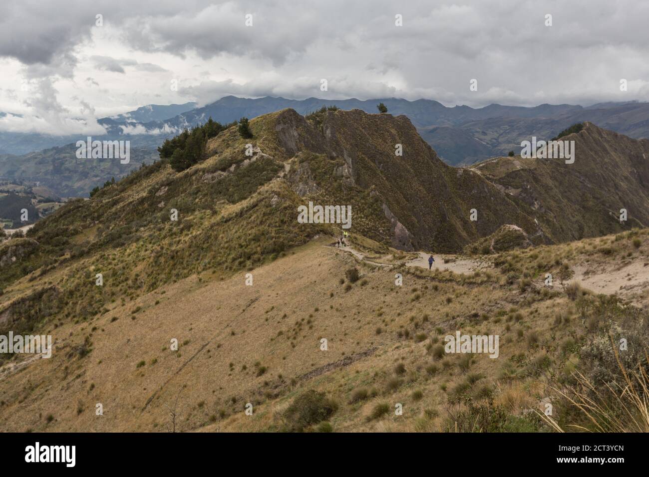 montagne avec végétation sèche, ciel nuageux et route de terre avec poussière Banque D'Images
