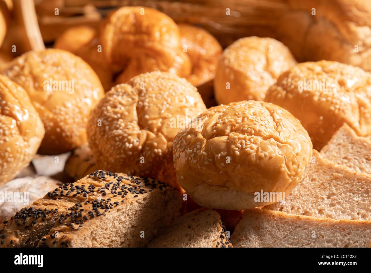 Gros plan UNE variété de petits pains au sésame mis ensemble sur la table avec la lumière du soleil. Banque D'Images