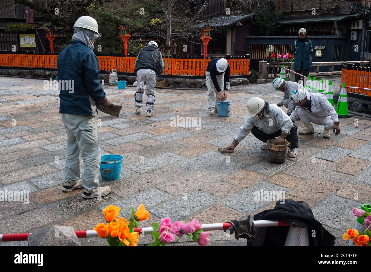 25.12.2017, Kyoto, Japon, Asie - UN groupe de travailleurs de la route refait surface de la route en pierre sur la rue piétonne de la vieille ville. Banque D'Images