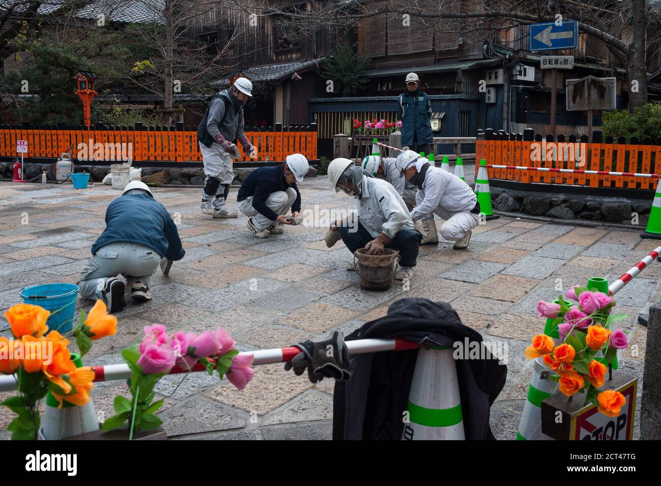 25.12.2017, Kyoto, Japon, Asie - UN groupe de travailleurs de la route refait surface de la route en pierre sur la rue piétonne de la vieille ville. Banque D'Images