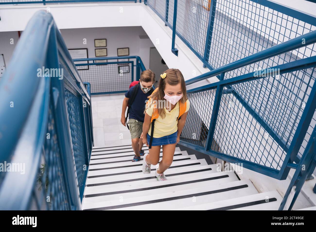 Les enfants de retour à l'école avec un masque maintenant la distance sociale pendant le covid. Banque D'Images