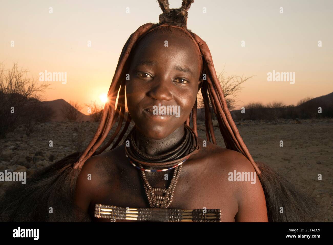 Une jeune femme Himba au coucher du soleil en Namibie. Banque D'Images