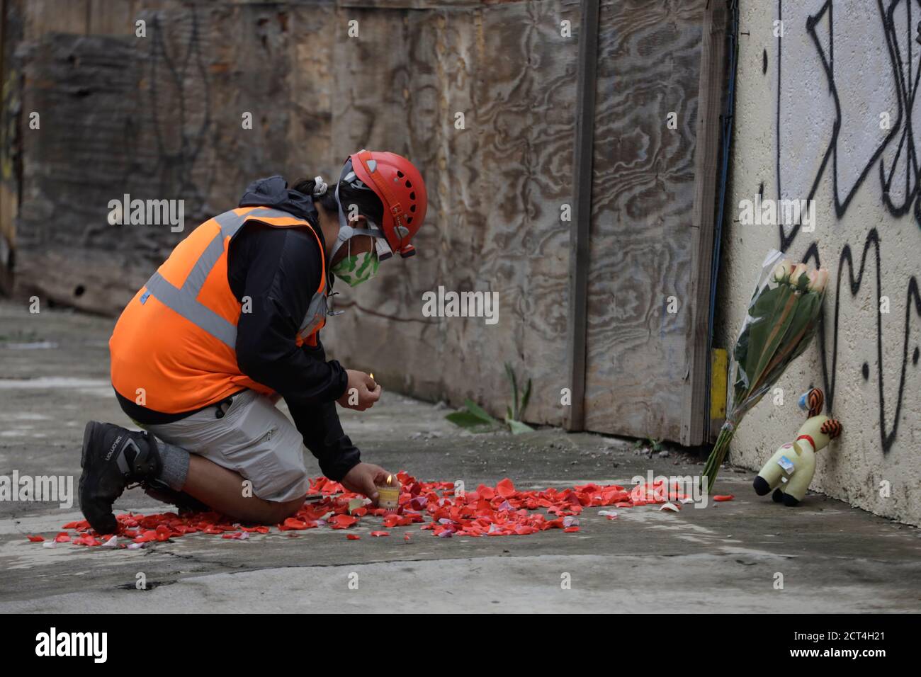 Non exclusif: MEXICO, MEXIQUE - SEPTEMBRE 19 : UNE lumière paramédique une bougie dans une offrande florale à la mémoire des 19 enfants et 7 adultes qui lo Banque D'Images