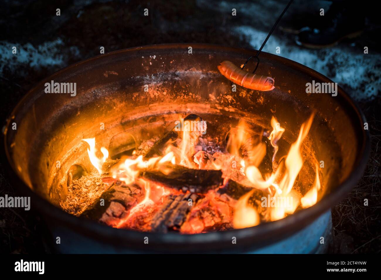 Cuire des saucisses sur le feu à ciel ouvert dans un camp en campant en Laponie finlandaise, Finlande, Europe Banque D'Images