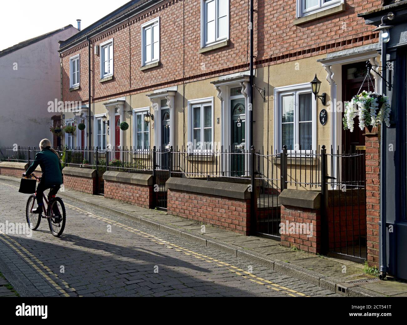 Femme pédalant le long de Wren Lane à Selby, dans le North Yorkshire, en Angleterre Banque D'Images