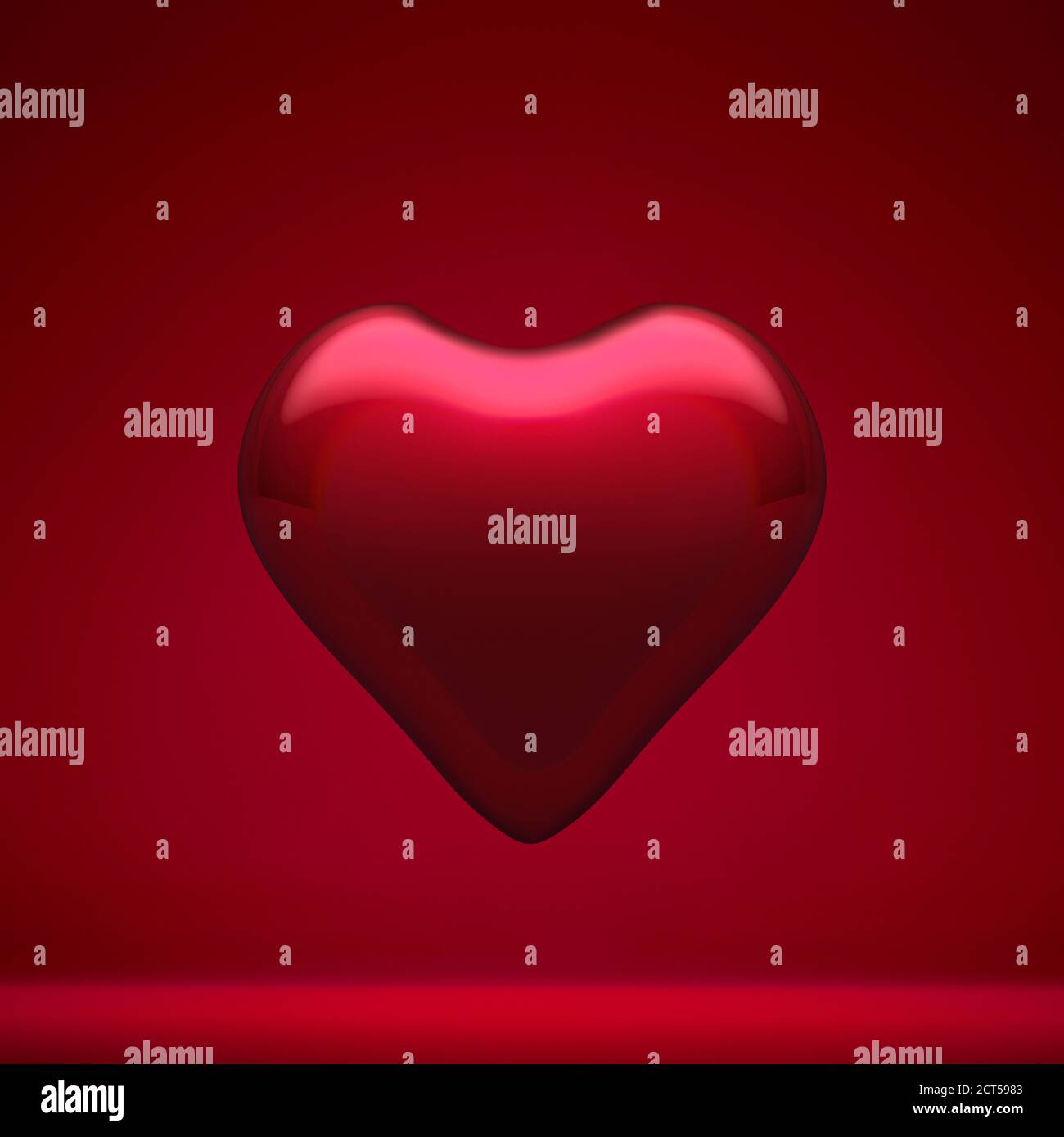 Coeur romantique en verre rouge brillant sur fond rouge. Décoration de Noël, concept d'atmosphère festive. Banque D'Images