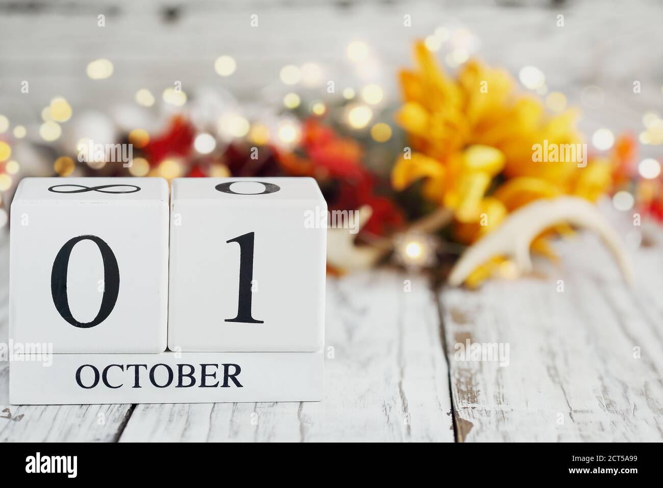 Blocs de calendrier en bois blanc avec la date du 1er octobre et décorations d'automne sur une table en bois. Mise au point sélective avec arrière-plan flou. Banque D'Images