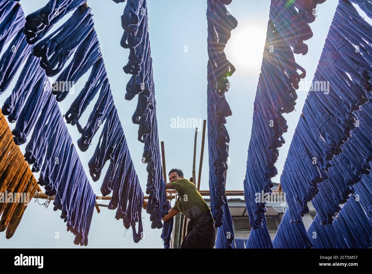 Soie teint bleu suspendue dans une usine de tissage de tissus à Amarapura, Myanmar Banque D'Images