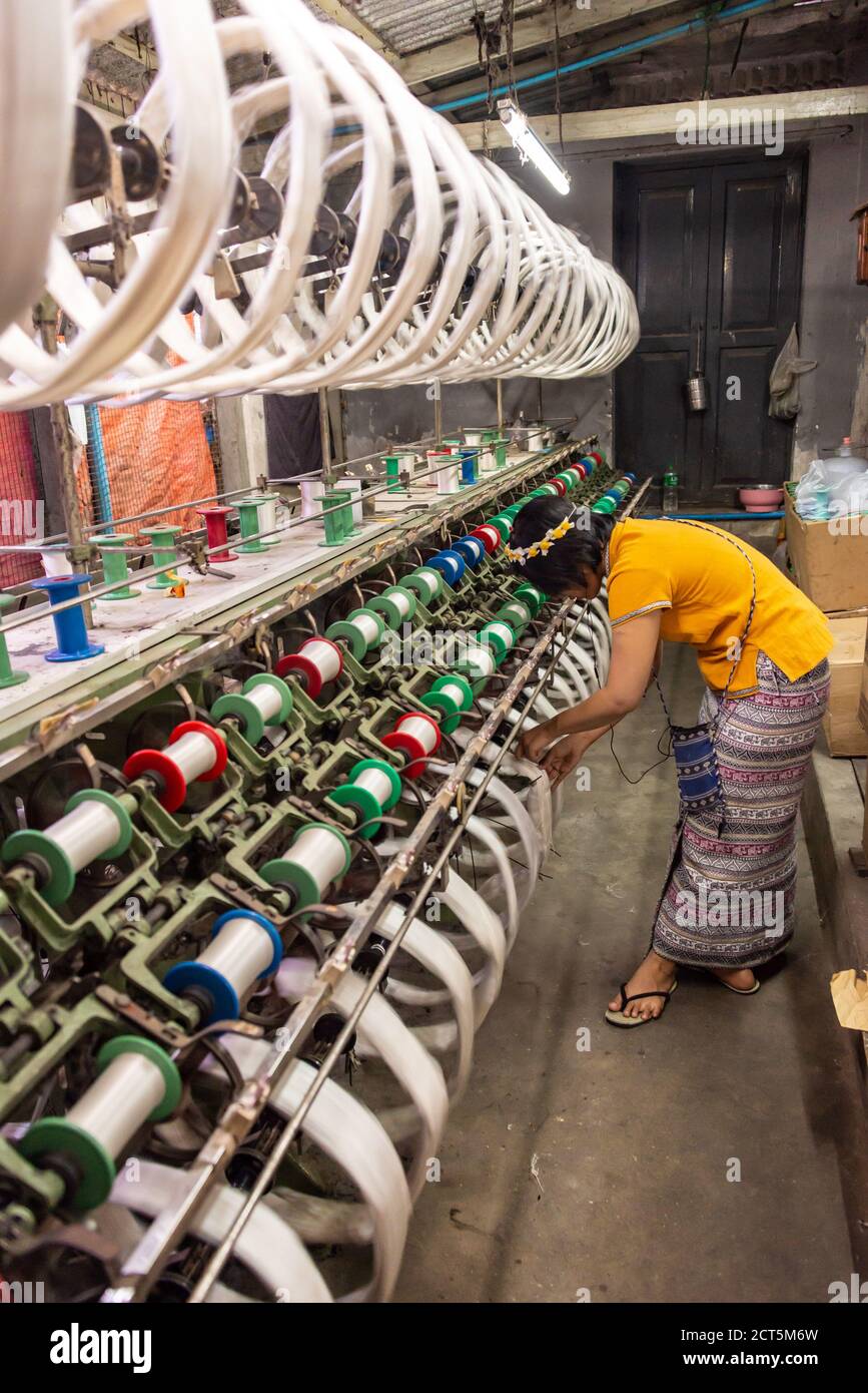 Femme travaillant dans un atelier de tissage de la soie, usine de textile à Amarapura, Birmanie Myanmar Banque D'Images