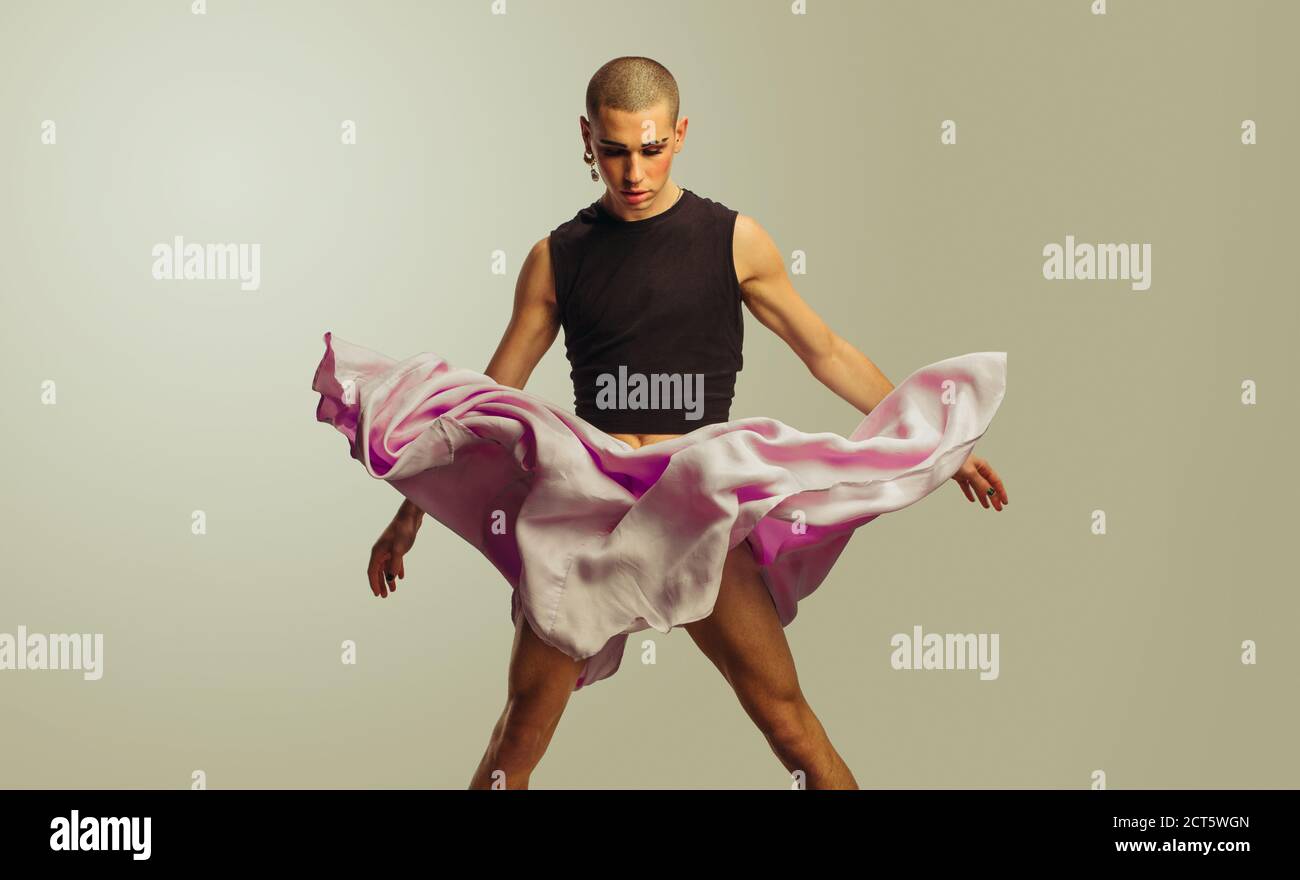 Homme liquide de sexe masculin avec jupe fluide dans l'air. Homme transgenre dansant dans un petit top et une jupe. Banque D'Images