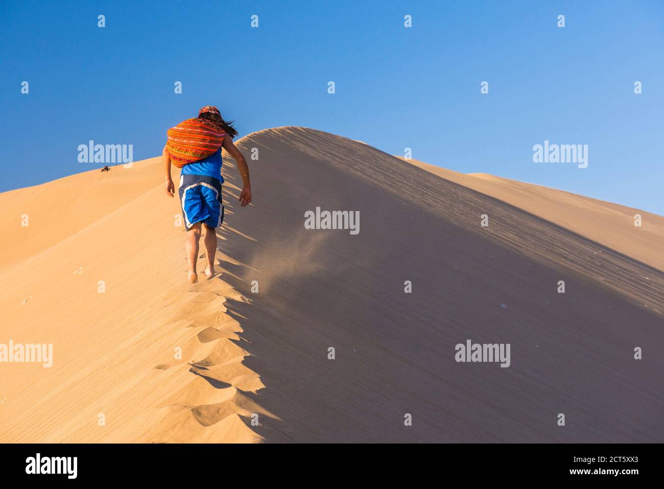 Touristes grimpant des dunes de sable au coucher du soleil à Huacachina, un village dans le désert, région ICA, Pérou, Amérique du Sud Banque D'Images
