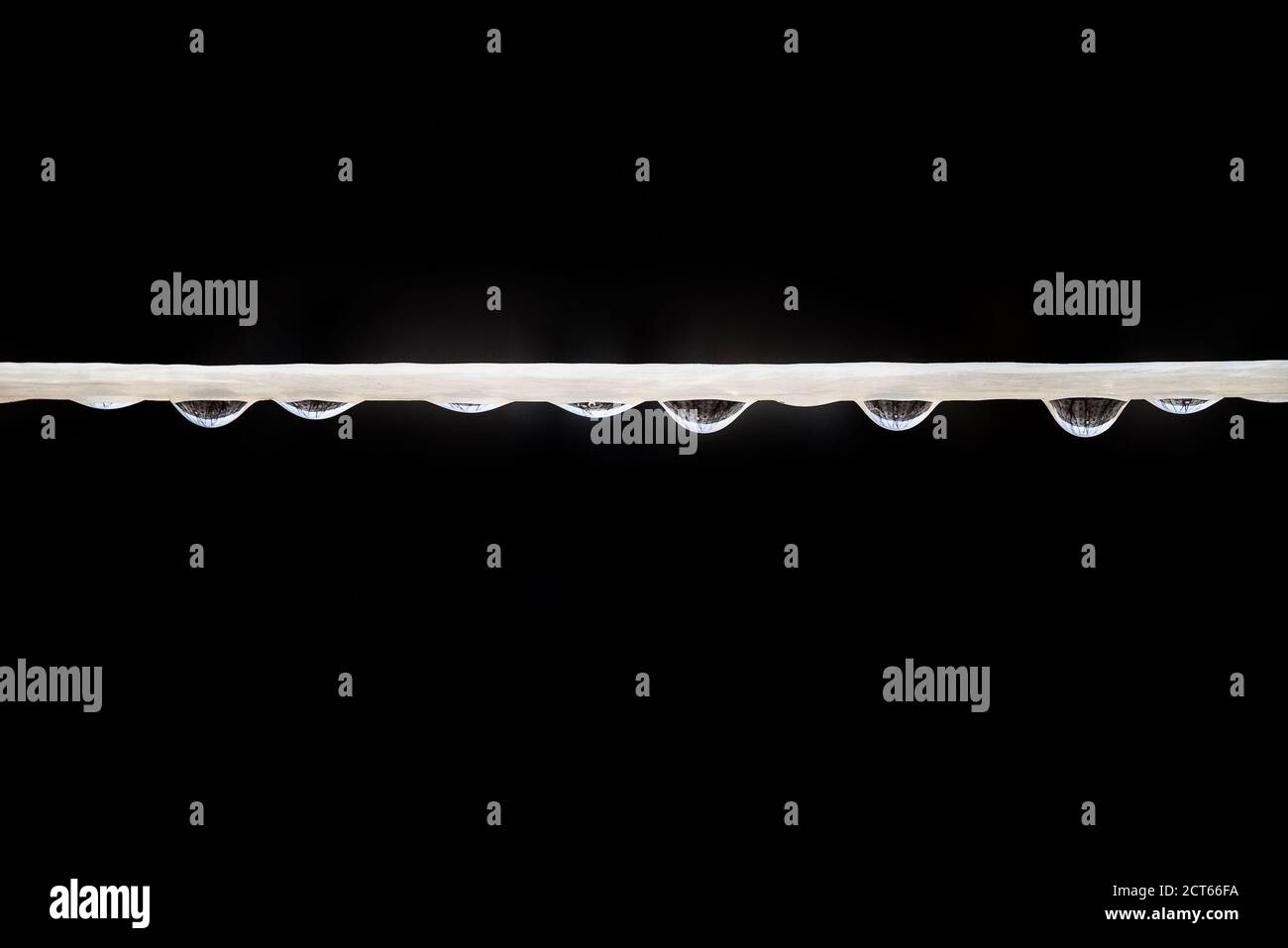Fil blanc avec de nombreuses gouttes d'eau sur fond noir Banque D'Images