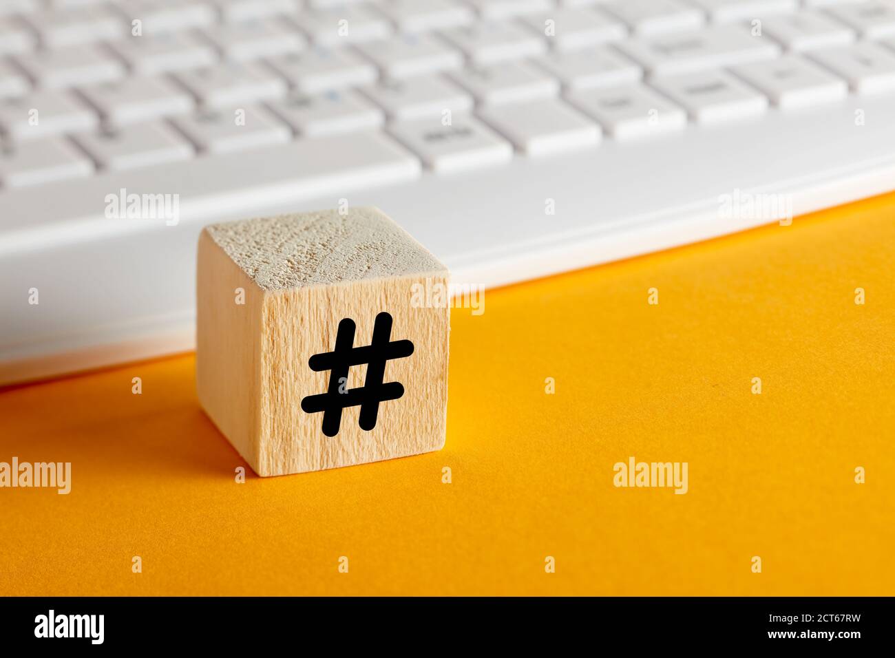 Symbole hashtag sur un cube en bois avec le clavier d'ordinateur sur fond  jaune avec espace de copie Photo Stock - Alamy
