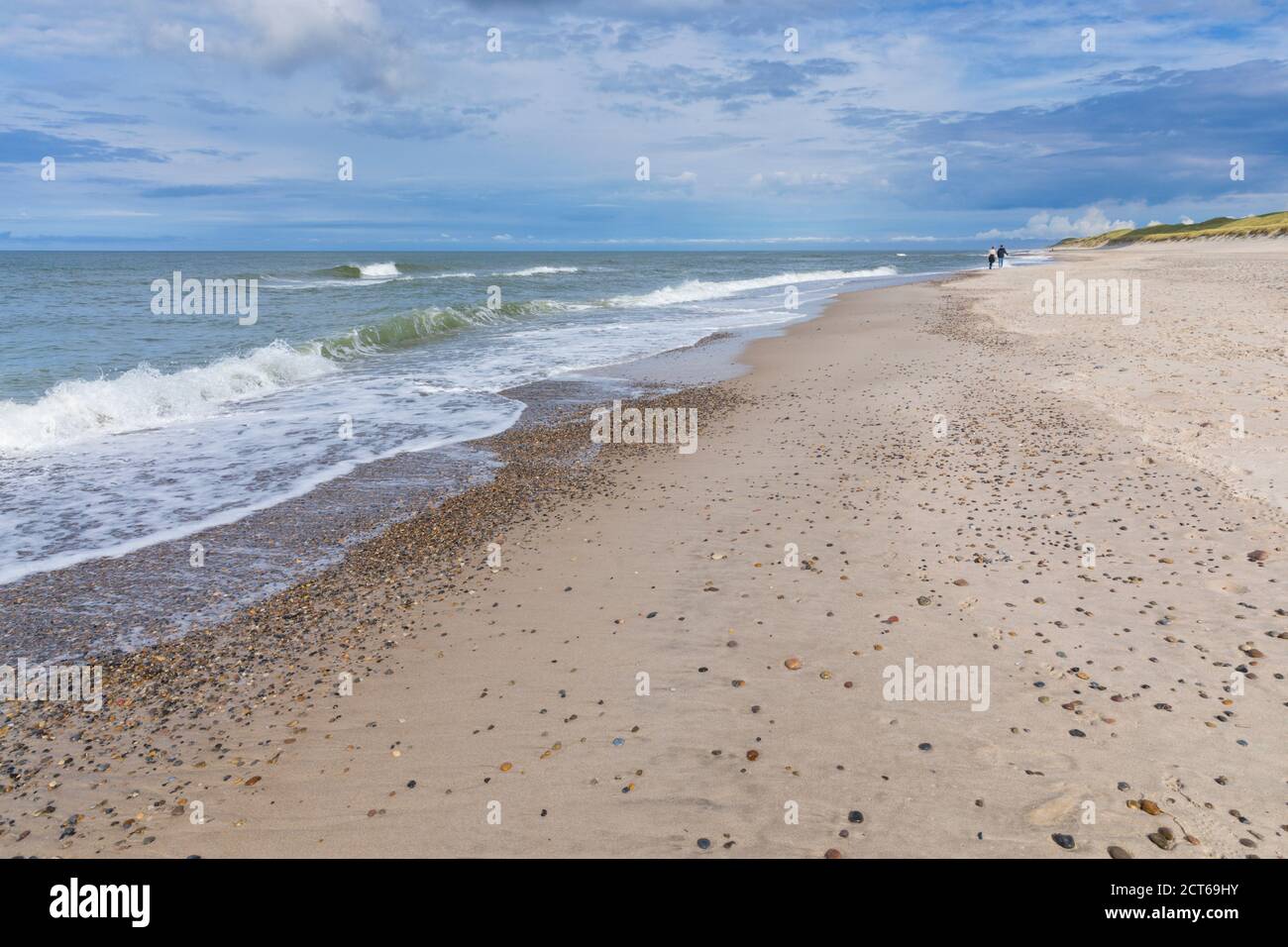 Deux personnes méconnaissables se promenant le long de la plage de Bjerregard on Côte danoise de la mer du Nord Banque D'Images