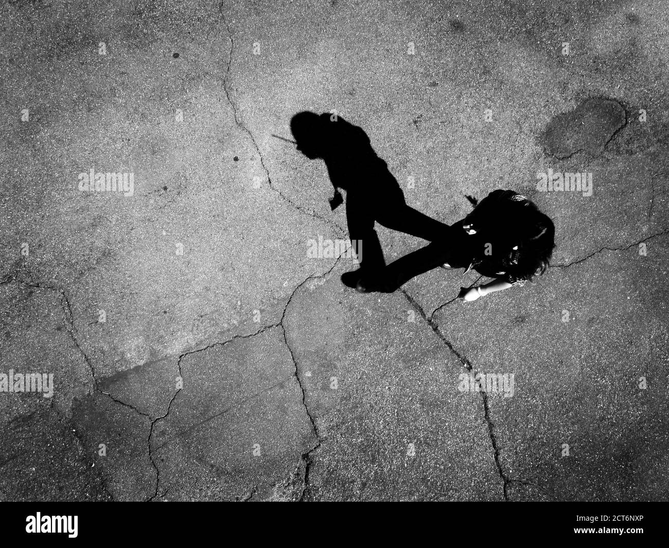 Plusieurs personnes marchant en dessous sur du béton avec des ombres aériennes vue de dessus Banque D'Images Plusieurs personnes marchant en dessous sur du béton avec des ombres aériennes vue de dessus Banque D'Images