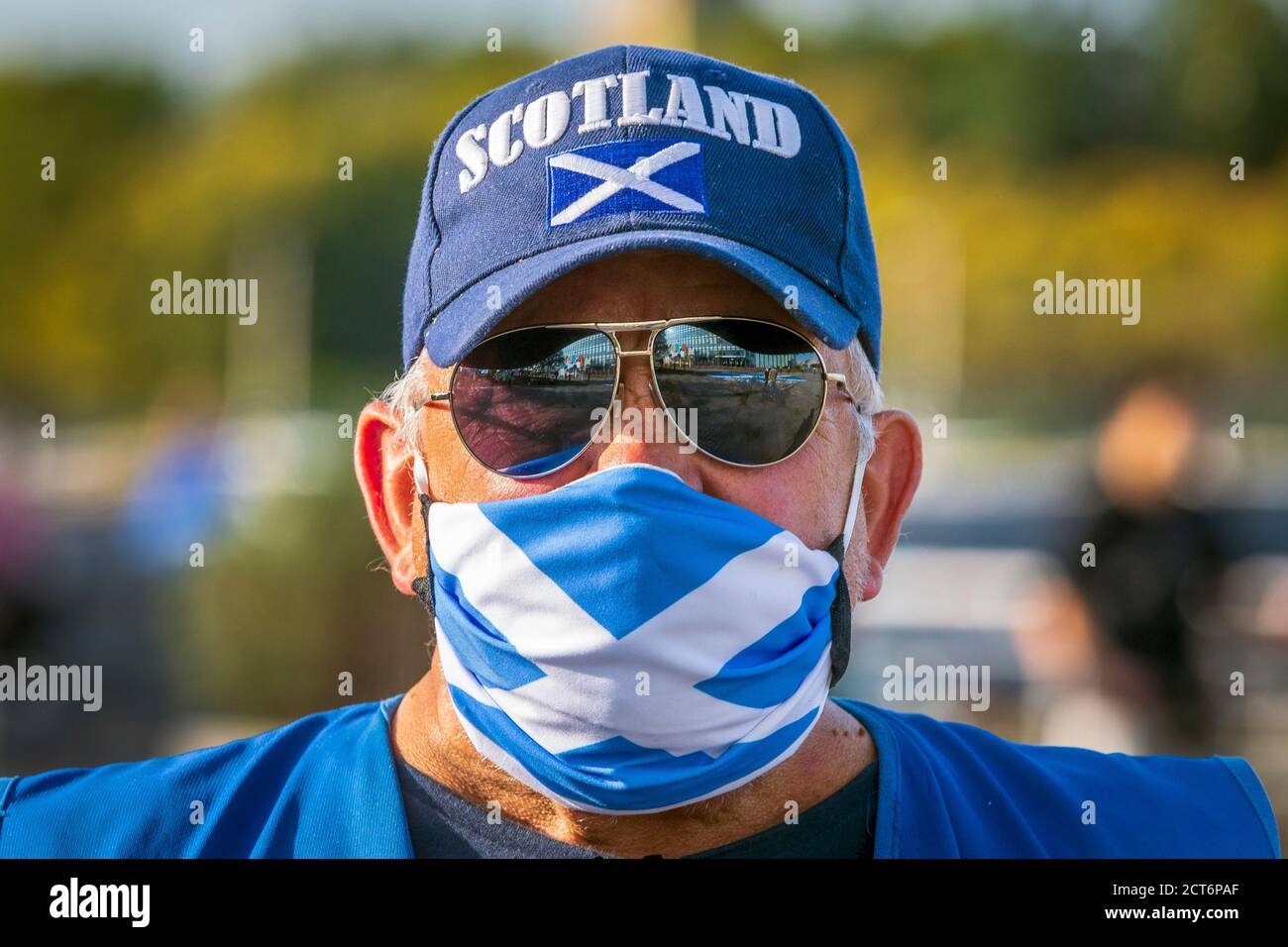 Scottish Independence supporter portant un masque de saltire visage une casquette de baseball logo'ed Scotland et des lunettes de soleil, pris lors d'un rallye politique d'indépendance, Banque D'Images