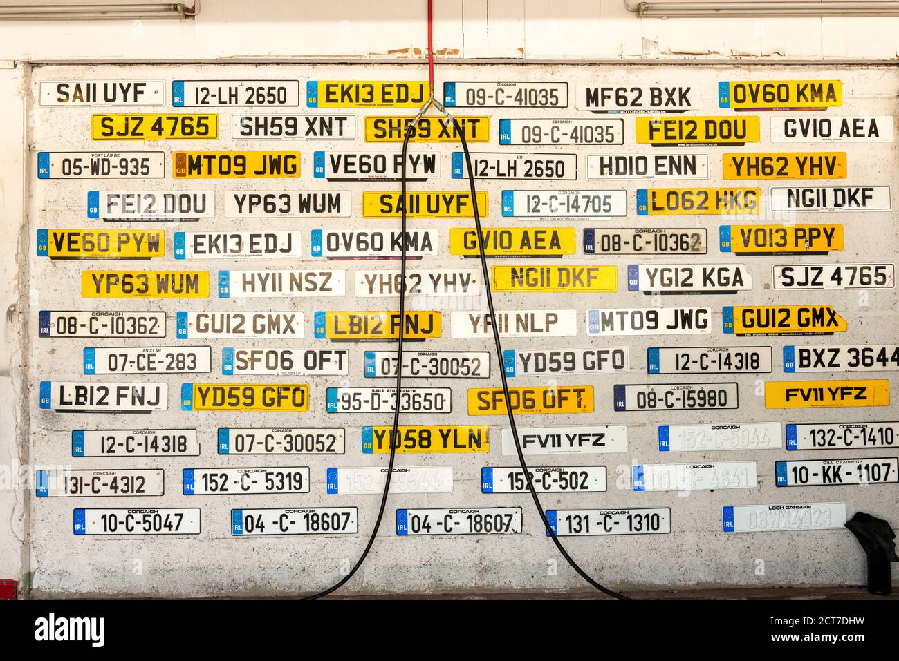 Détail du garage de service de voiture avec de vieilles plaques d'immatriculation britanniques et irlandaises abandonnées affichées sur le mur Banque D'Images