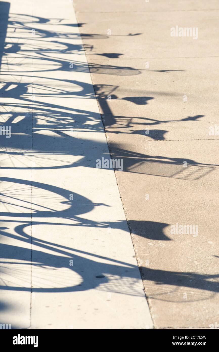 ombres des vélos garés dans une rangée.L'ombre des vélos en perspective. Photo abstraite, mise au point sélective, personne Banque D'Images