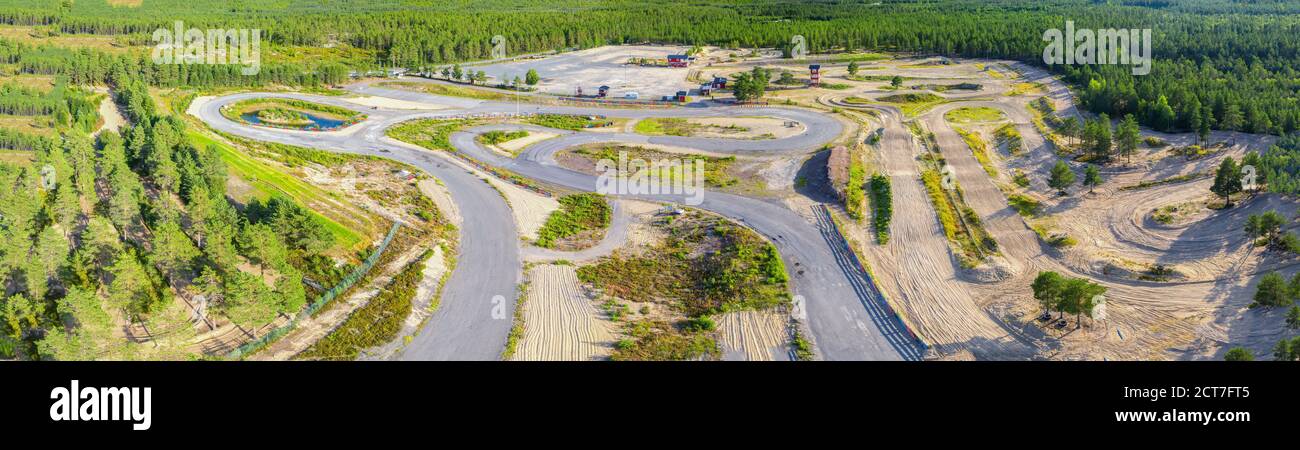 Panorama aérien à couper le souffle de la forêt de pins verts scandinaves et une partie de l'entraînement de speedway ci-dessous. Jour d'été ensoleillé. Balayage typique du nord Banque D'Images