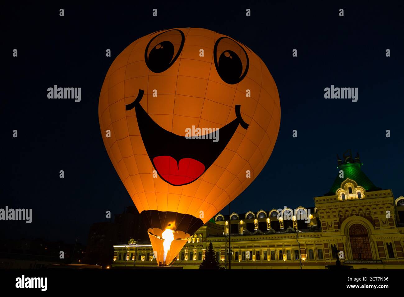 Hot Air Balloon avec smiley jaune au festival de nuit Banque D'Images