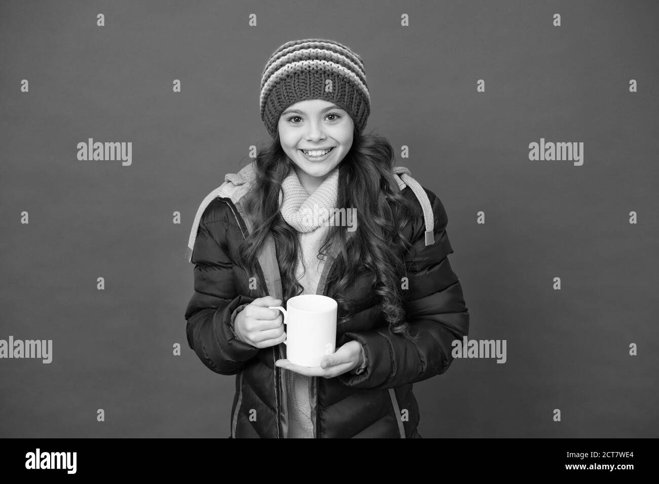 Bonjour matin. J'ai besoin de cappuccino. Un enfant heureux peut prendre un thé le matin. Une petite fille tient un mug avec une boisson chaude. Sa coupe du matin pour la journée froide d'hiver. Réveil du matin pour le petit-déjeuner. Banque D'Images