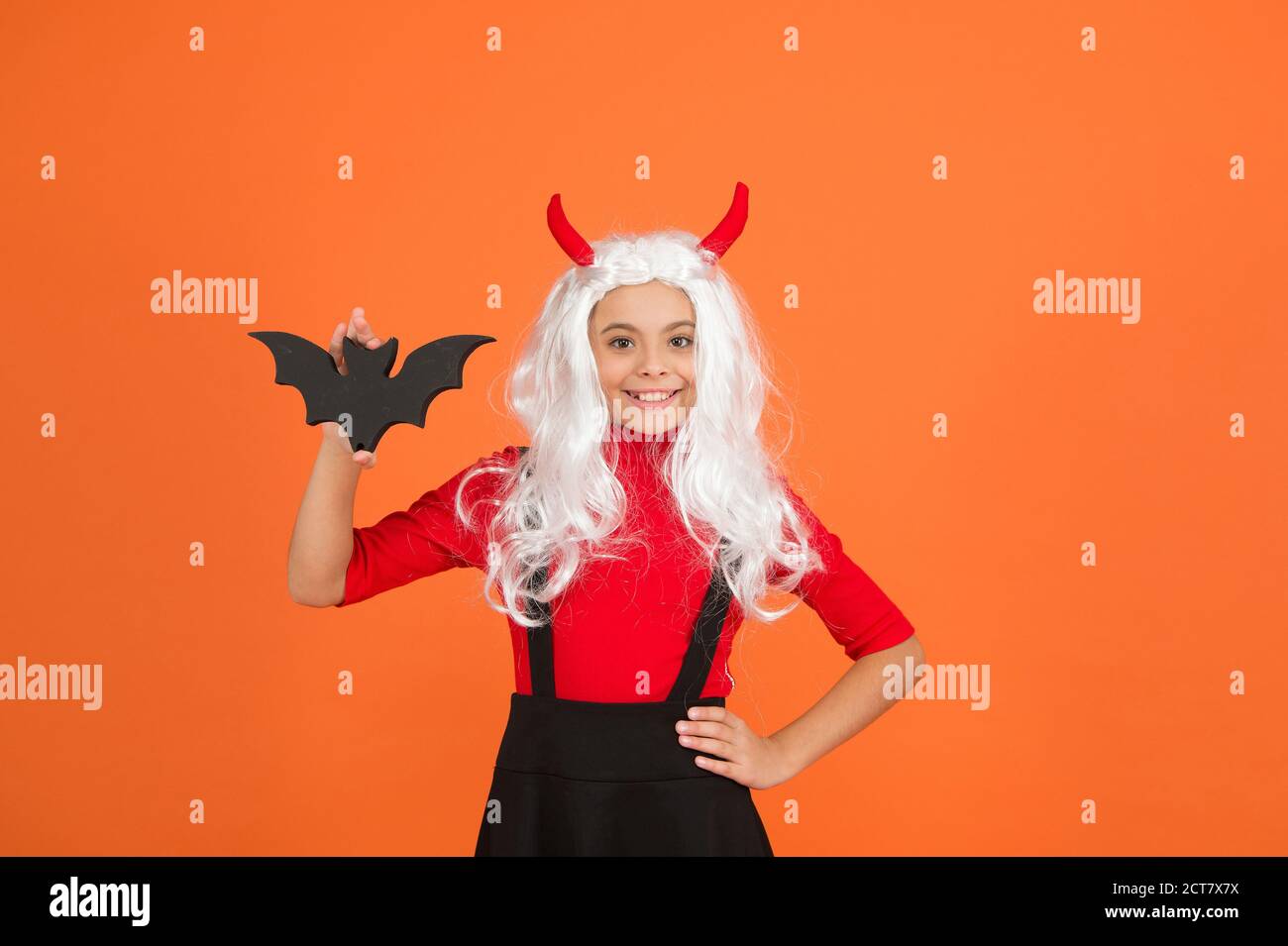 chauve-souris mignonne. enfant avec une petite chauve-souris. jeune fille  porte une perruque à cheveux longs et bouclés blanches pour la fête.  vacances d'automne. loisirs d'enfance. fête déguisée. joyeux halloween.  enfant porte des