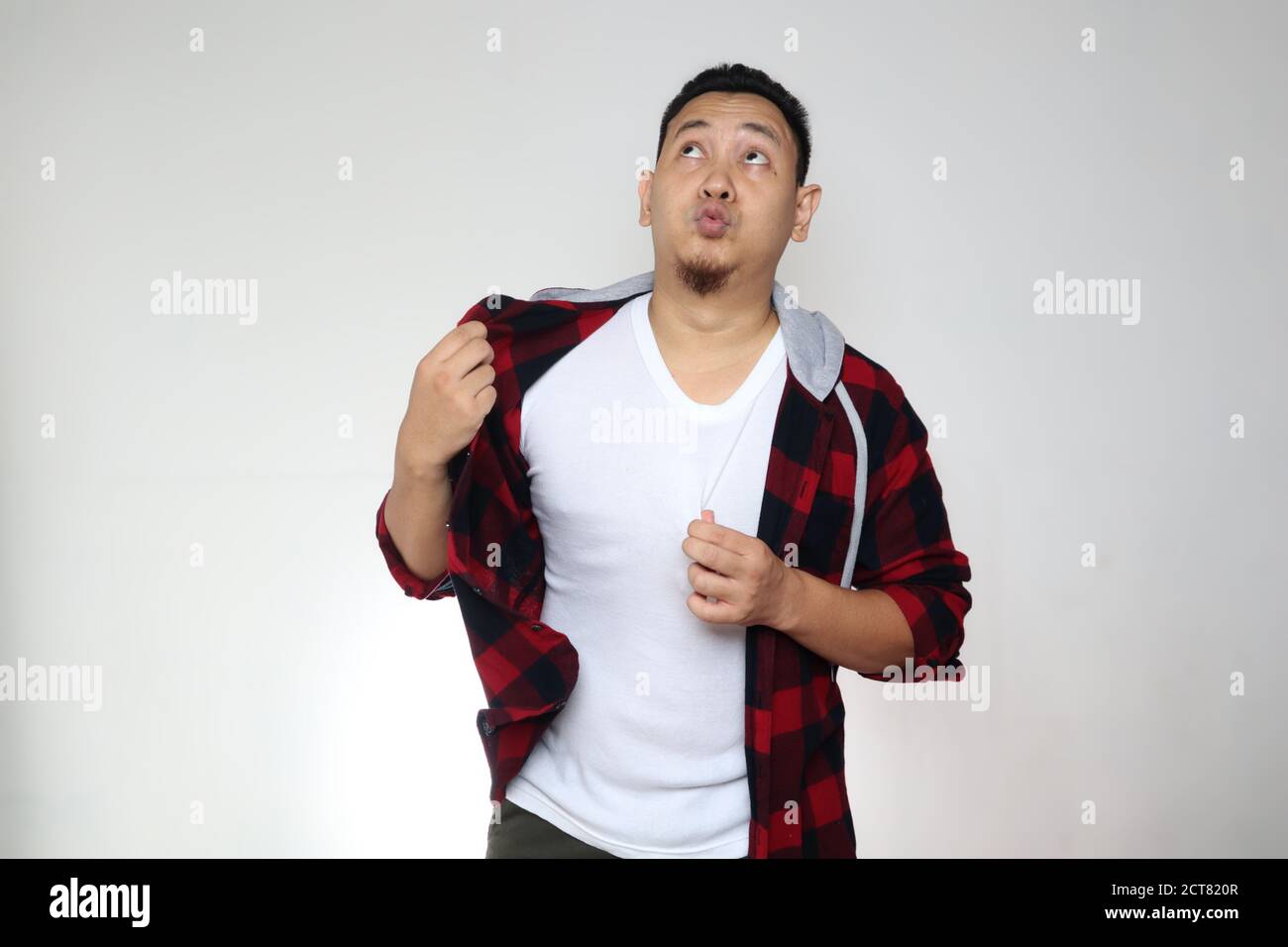 Drôle jeune homme asiatique souffrent d'étouffement chaud, sueur sensation inconfortable, sur fond blanc Banque D'Images