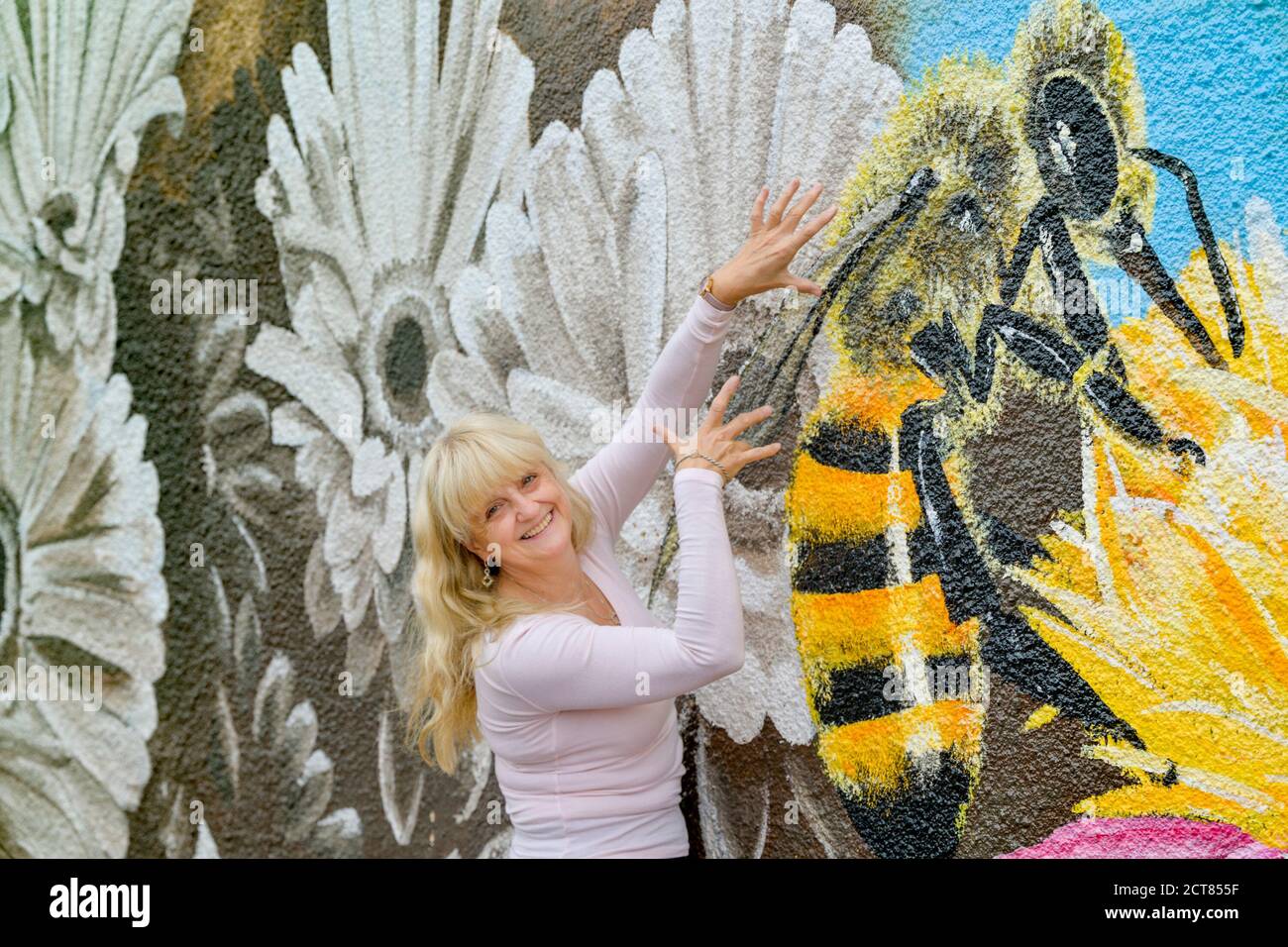 Femme pose à la fleur, murale d'abeille par l'artiste Judy Pohl, Langley (Colombie-Britannique), Canada Banque D'Images