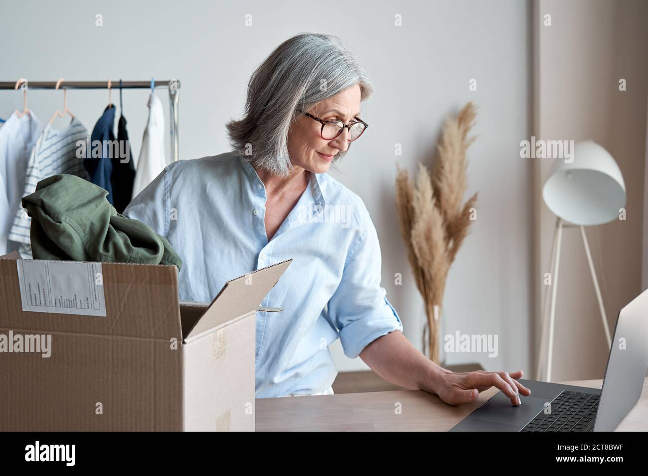 Femme dropshipping habillement propriétaire d'affaires paquet commande dans la boîte d'expédition de livraison. Banque D'Images