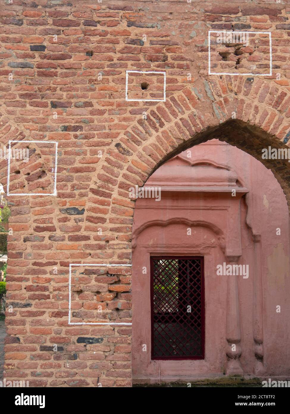 des marques de balles sur un mur entourent une arche au site du massacre de bagh de jallianwala à amritsar, en inde Banque D'Images