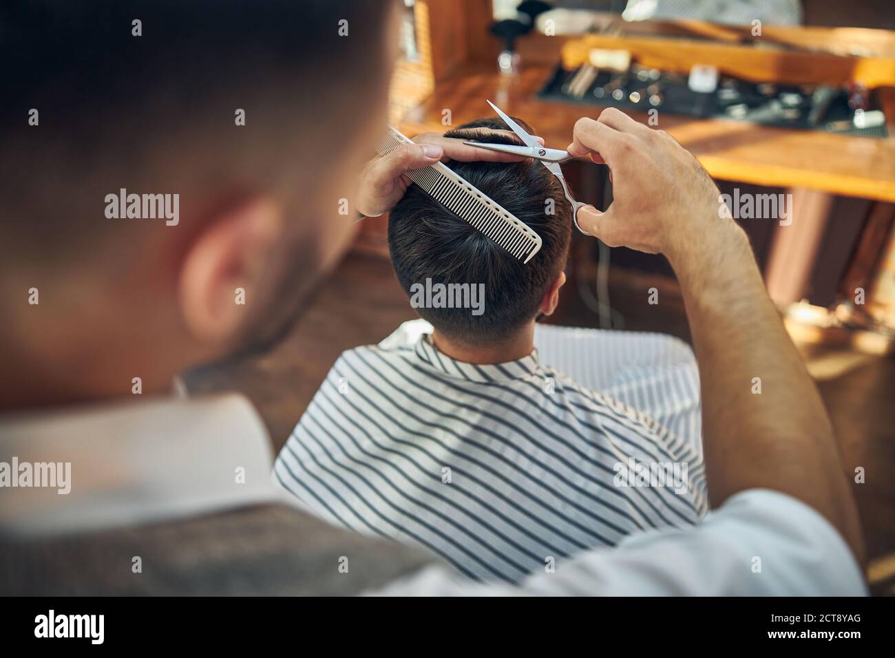 Coiffeur professionnel travaillant sur une coupe de cheveux fraîche pour son client Banque D'Images