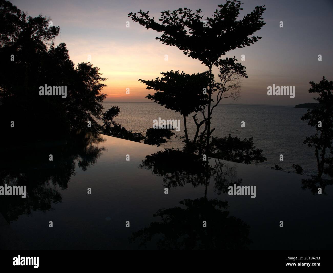 Vue sur une piscine à débordement au coucher du soleil sur l'île six Senses Krabey, Cambodge Banque D'Images