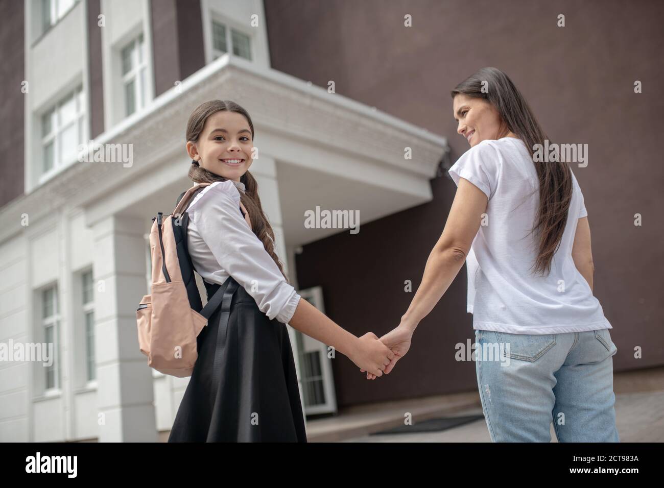 Maman et fille vont à l'école ensemble et se sentent bien Banque D'Images