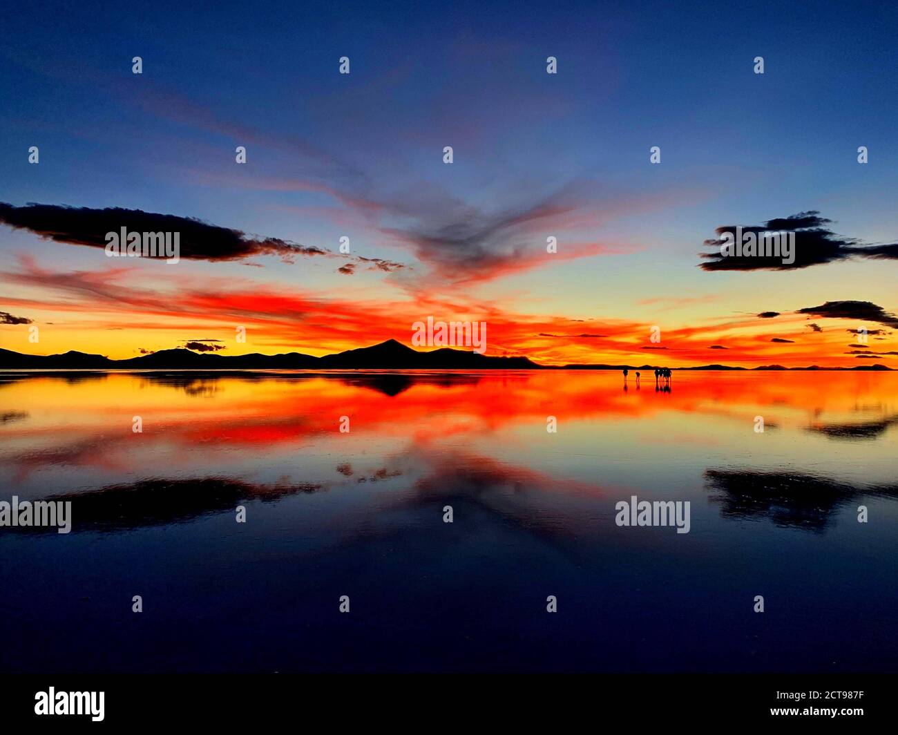 Coucher de soleil spectaculaire sur le lac salé, Salar de Uyuni, Bolivie. Paysage magnifique du désert Atacama. Coucher de soleil surréaliste rouge flamboyant sur les appartements salins d'Uyuni. Banque D'Images