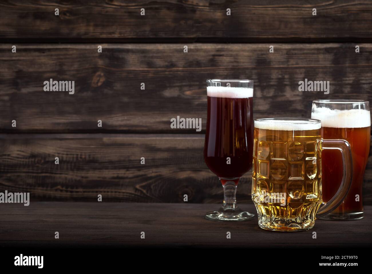 Différentes sortes de bière pression en verres et mug sur table en bois, espace de copie. Bière fraîche brassée. Banque D'Images