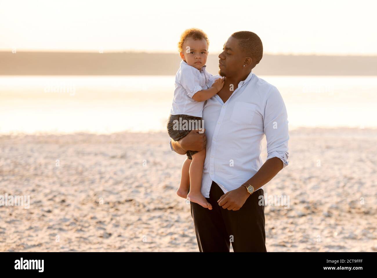 Portrait du jeune père et du petit-fils sérieux. Bébé garçon sur les mains du père Banque D'Images
