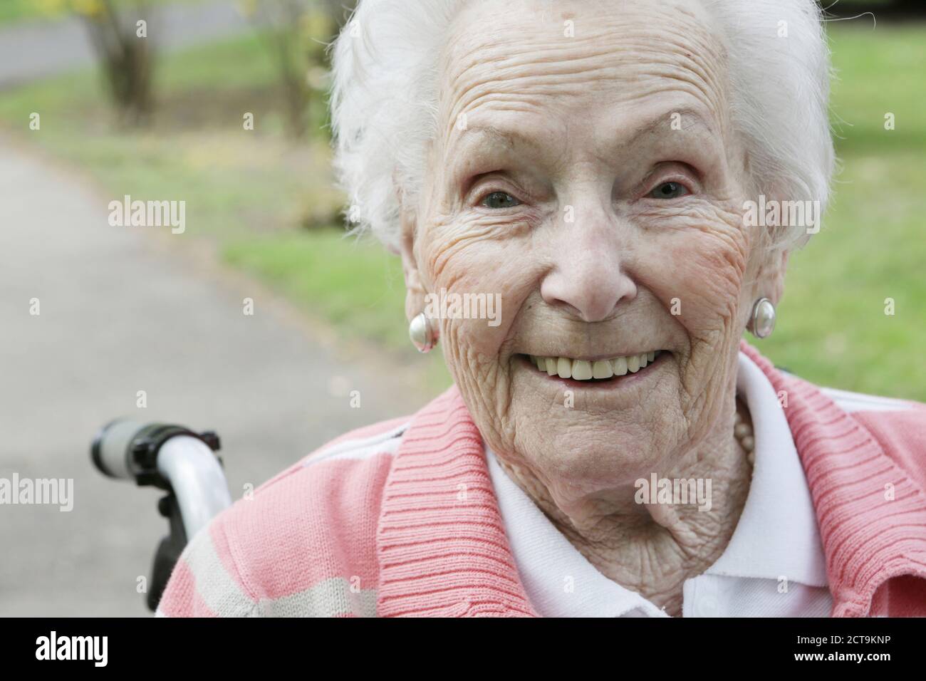 Allemagne, North Rhine Westphalia, Cologne, Portrait of senior woman sitting sur fauteuil roulant, smiling Banque D'Images