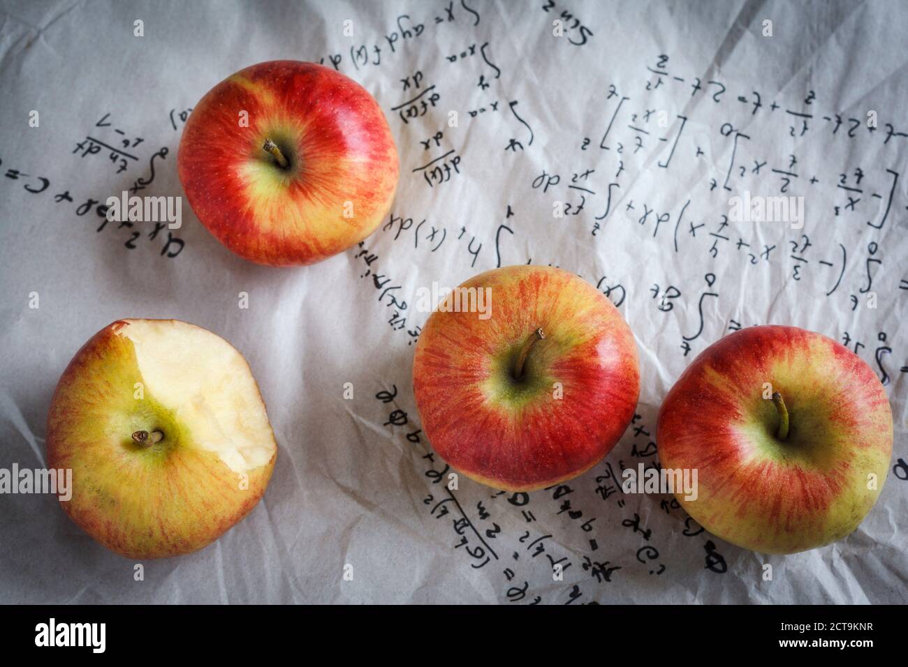 Quatre pommes couché sur papier avec des formules, studio shot Banque D'Images