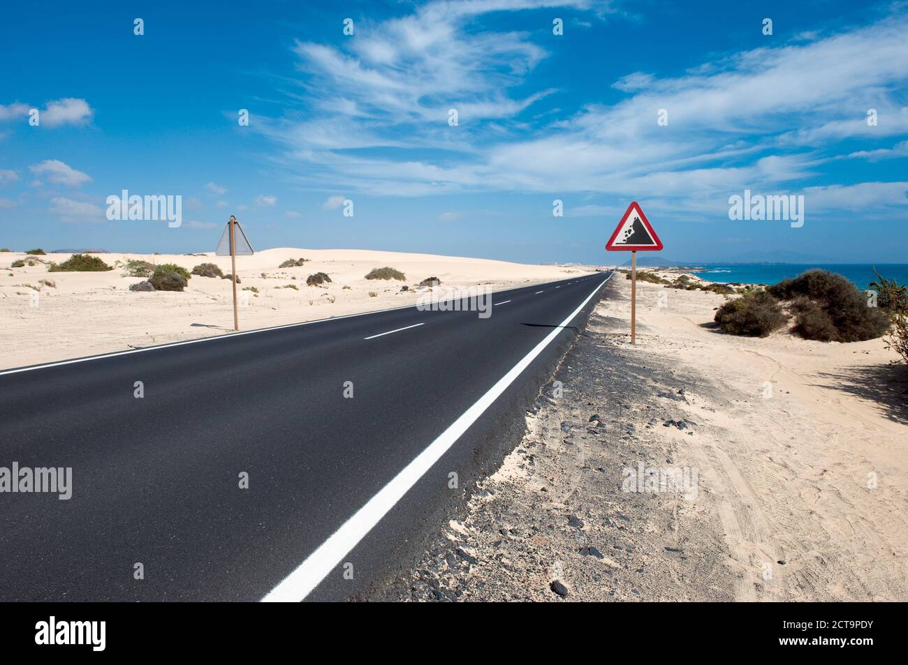Espagne, Fuerteventura, Corralejo, Parque Natural de Corralejo, vue de la route vide et road sign Banque D'Images