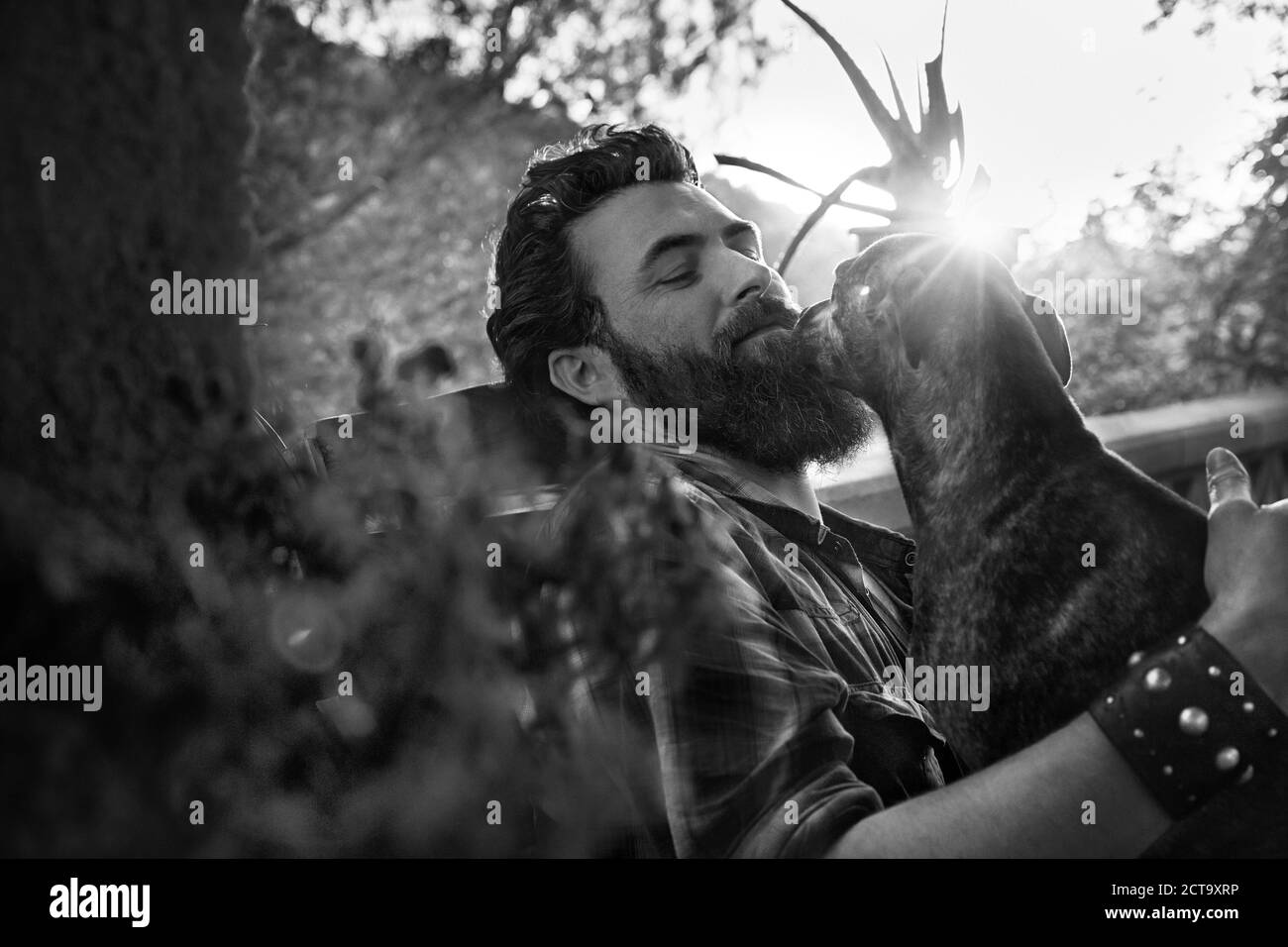 Smiling man with dog on porch Banque D'Images