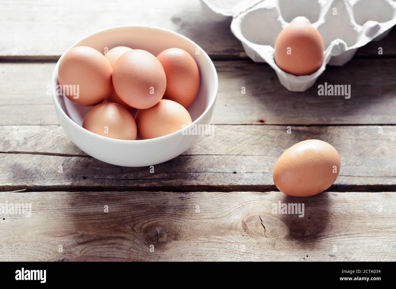 Studio, brown les oeufs dans un bol sur une table en bois Banque D'Images