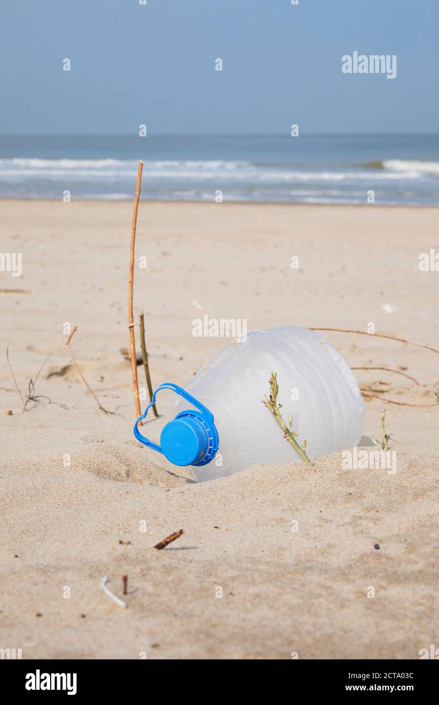 Belgique, bouteille en plastique vide couché sur sable à la côte de la mer du Nord Banque D'Images