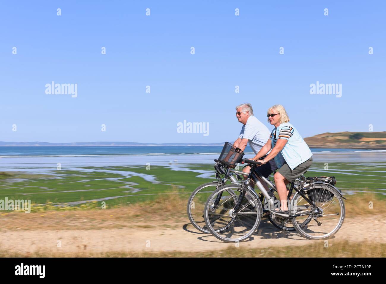 France, Bretagne, Finistère, Senior couple on e-bikes à la côte Banque D'Images